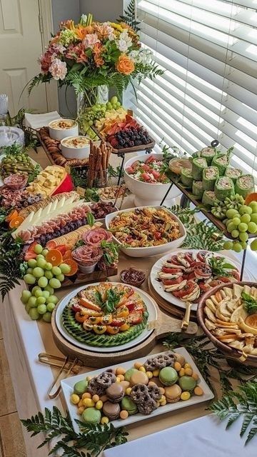Rijkelijk buffet met fruit, kaas, hapjes en bloemstukken